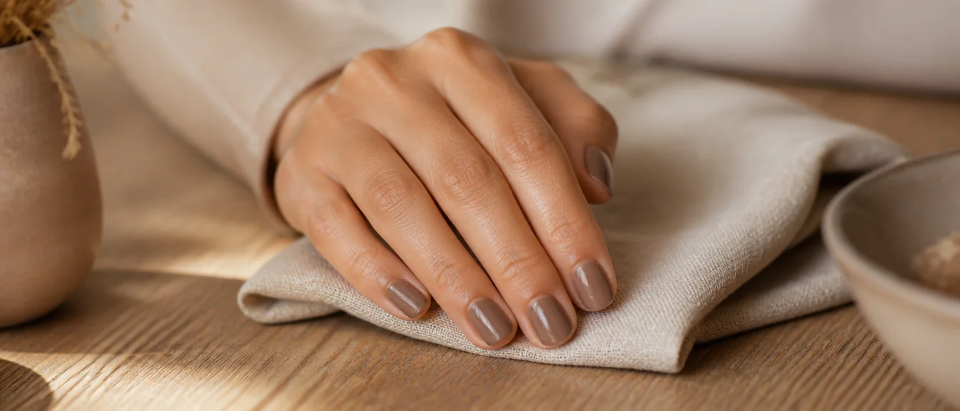 Very short round natural nails in a glossy classy taupe
