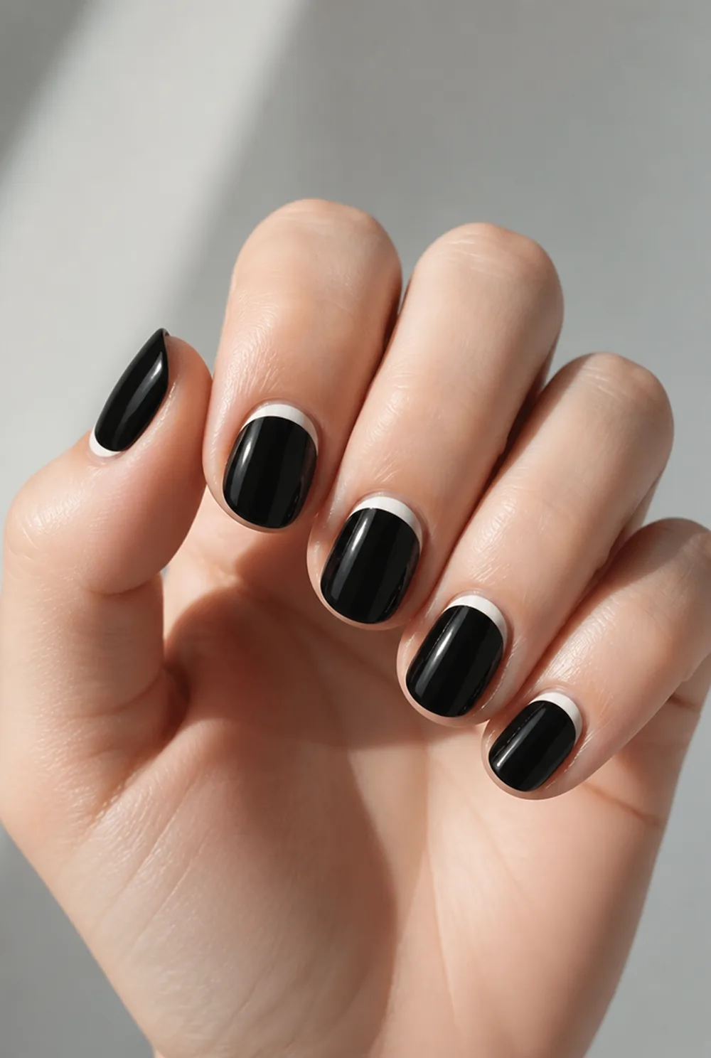 half-moon contrast nail art on fair skin, short length