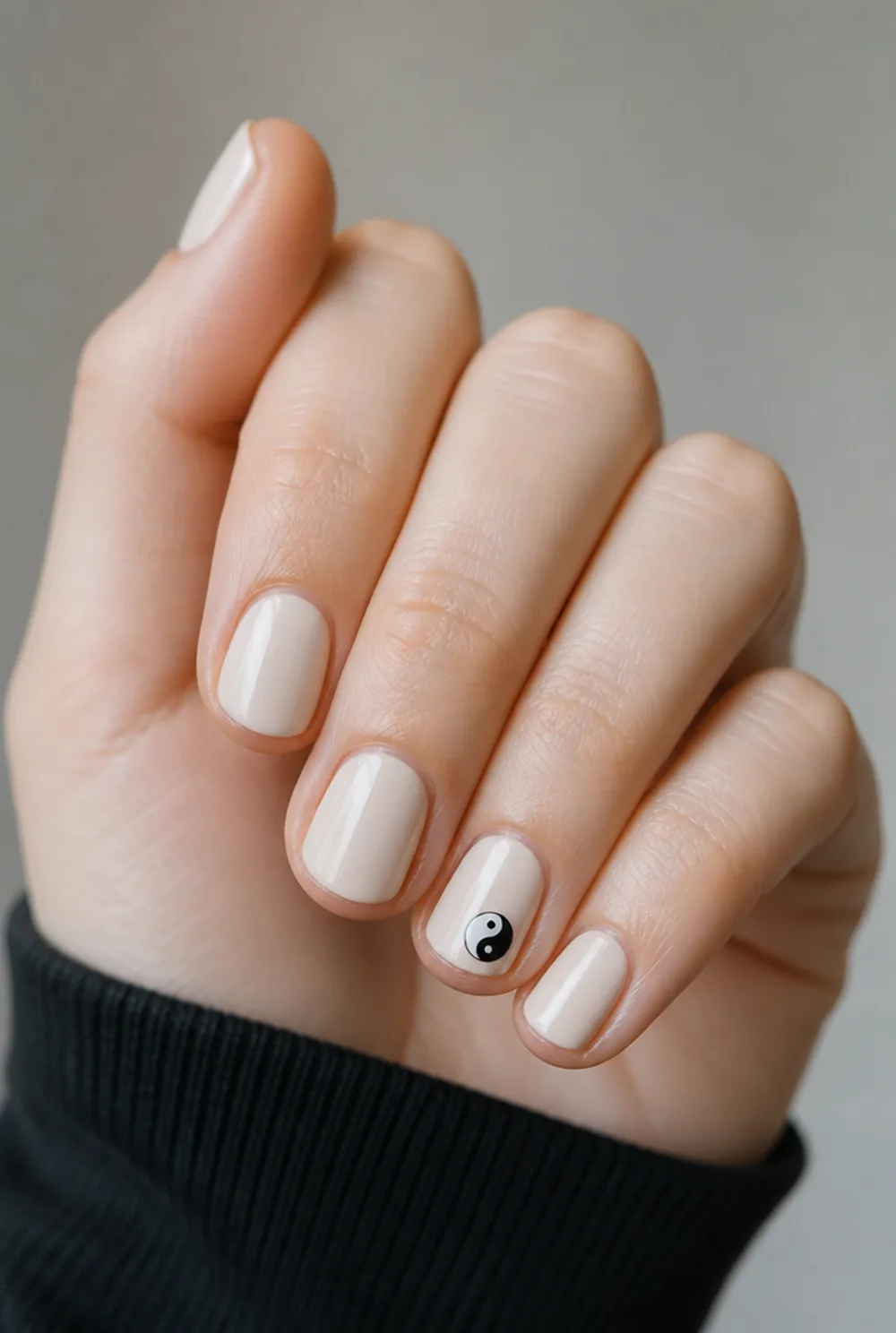 yin-yang minimal nail art on fair skin, short length