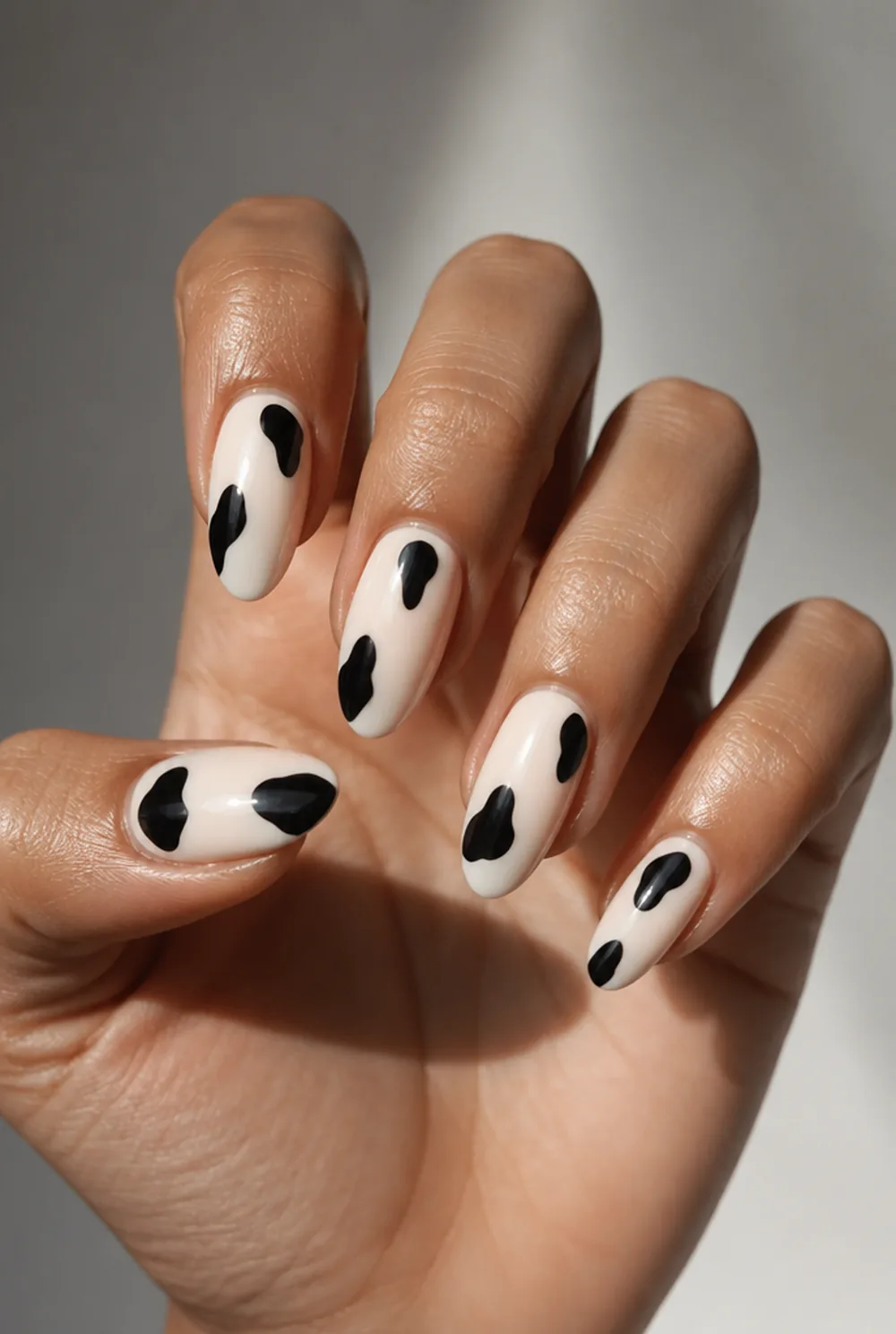 tasteful cow print nail art on olive skin, long length
