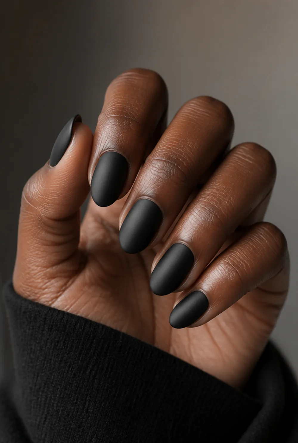 matte black almond nail art on deep brown skin