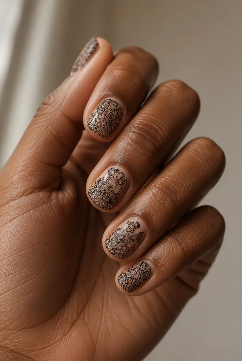 black lace nail art on deep brown skin