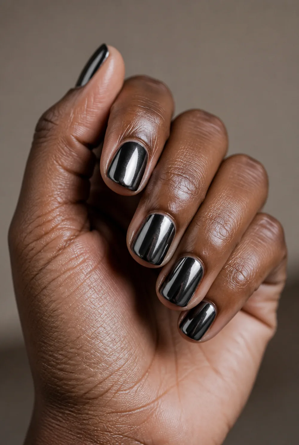 black chrome nail art on deep brown skin