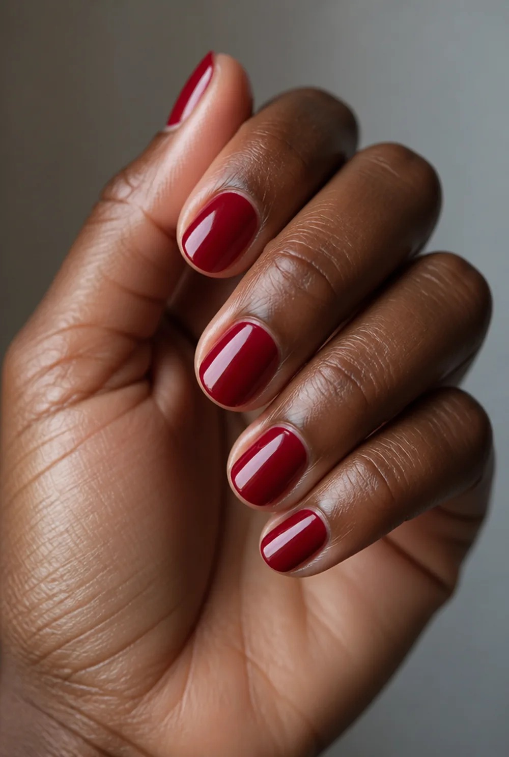 cherry red round nail art on deep brown skin