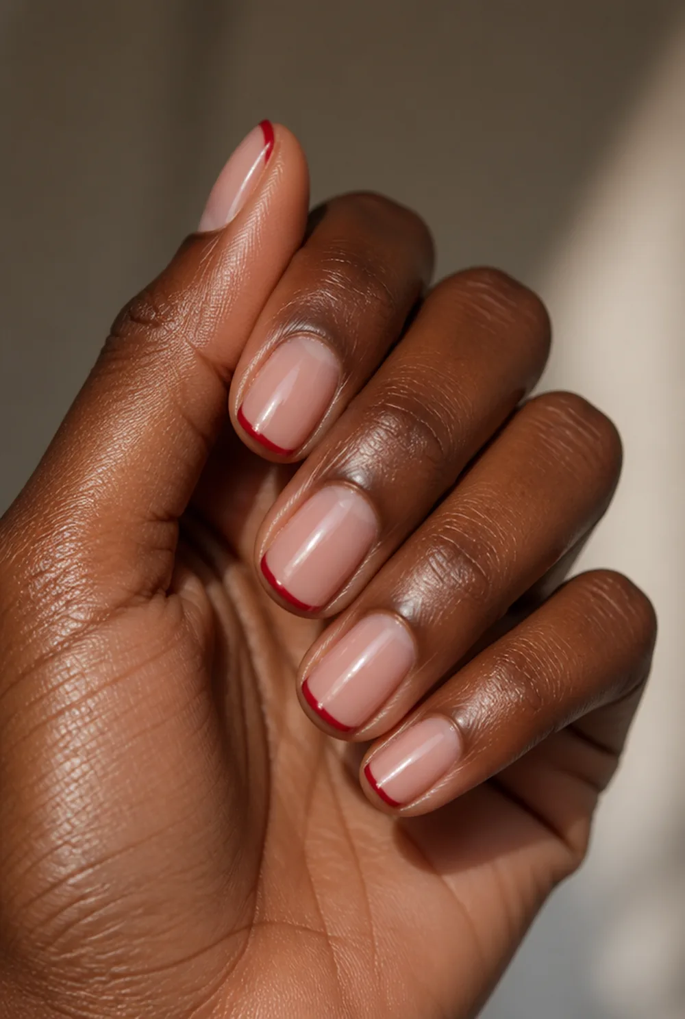red micro french nail art on deep brown skin