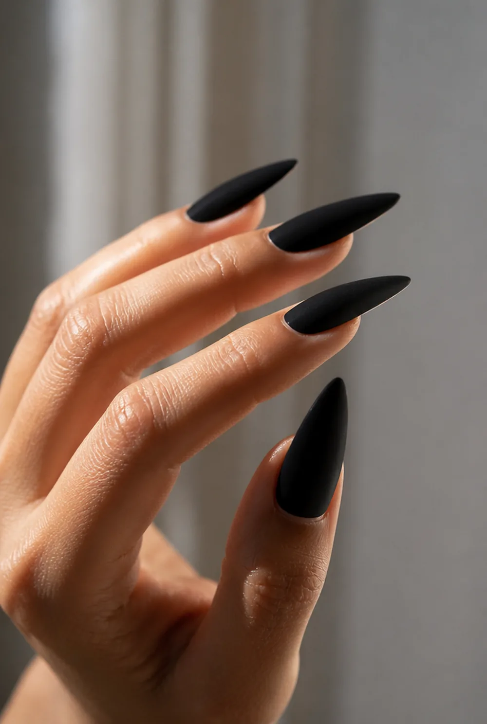matte noir stiletto nail art on olive skin, long length