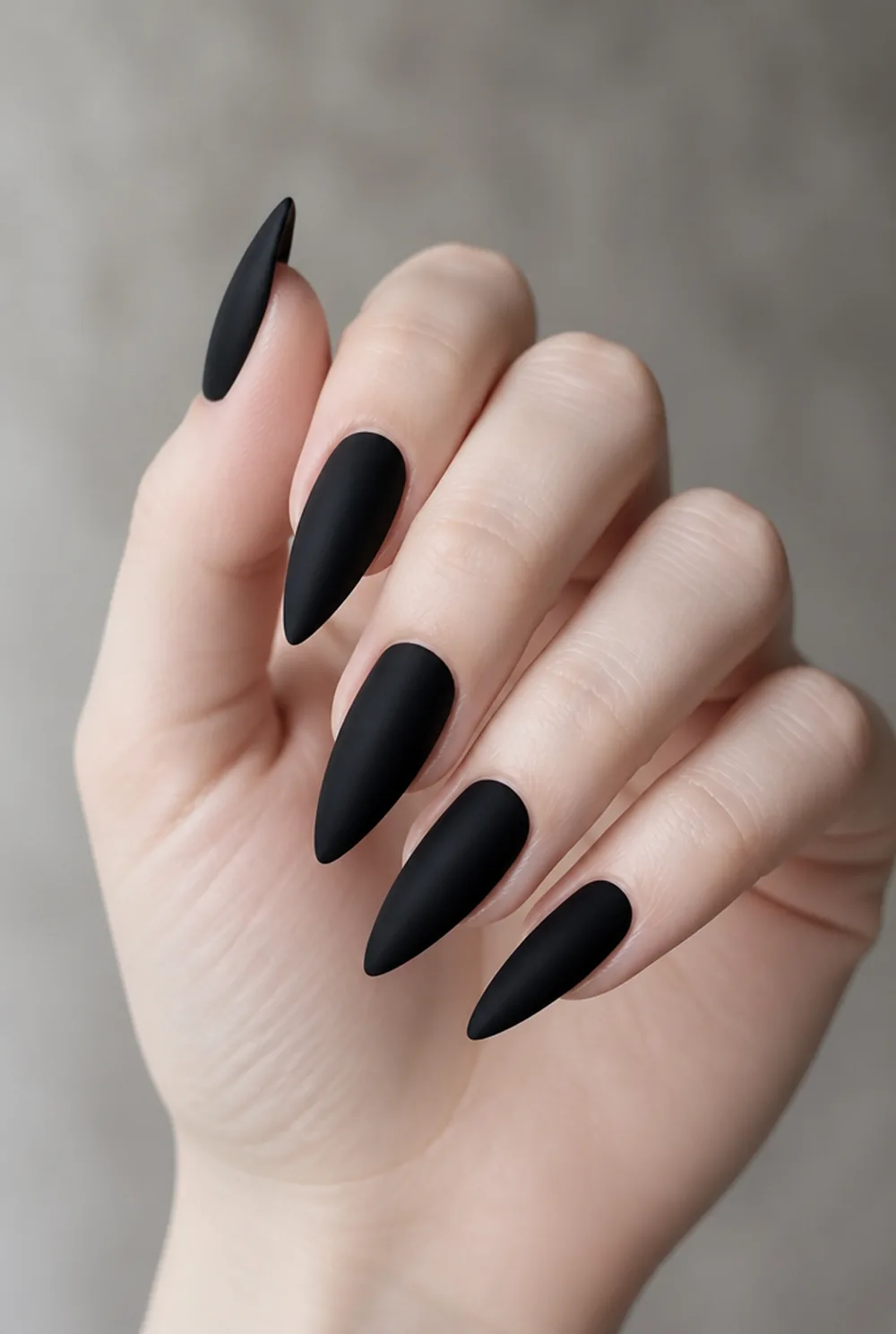 matte noir stiletto nail art on fair skin, short length