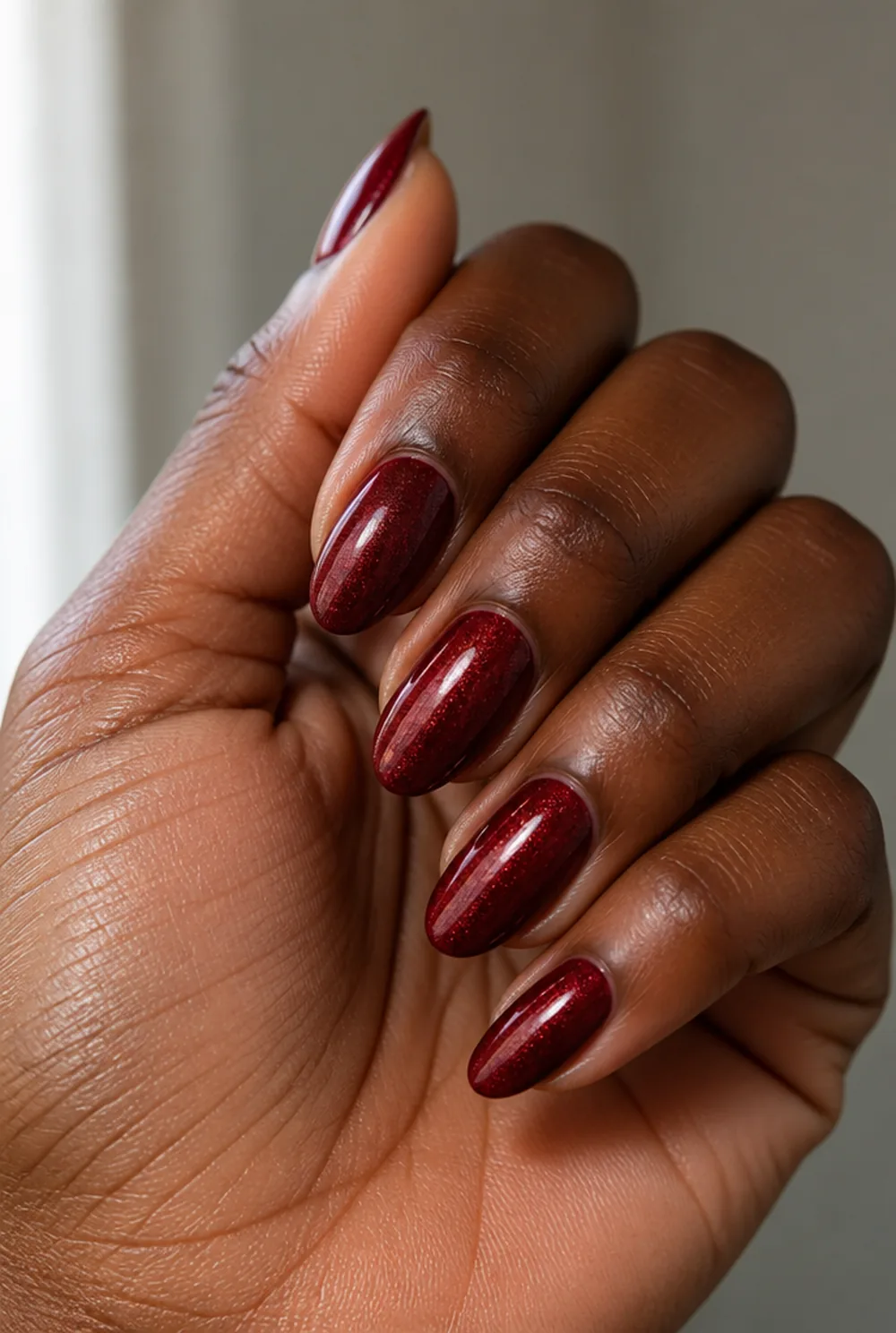 garnet shimmer nail art on deep brown skin