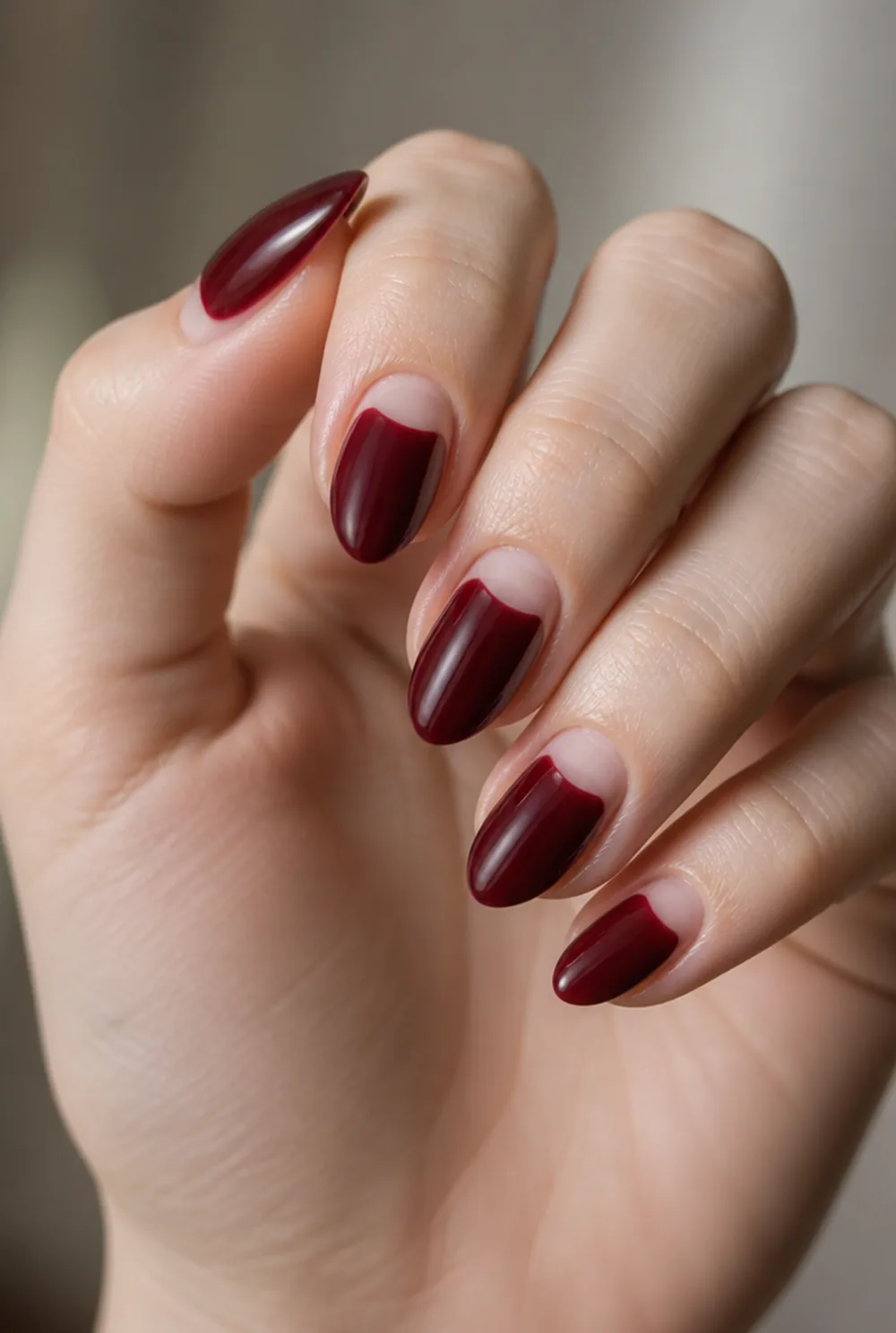bordeaux half-moons nail art on fair skin, short length