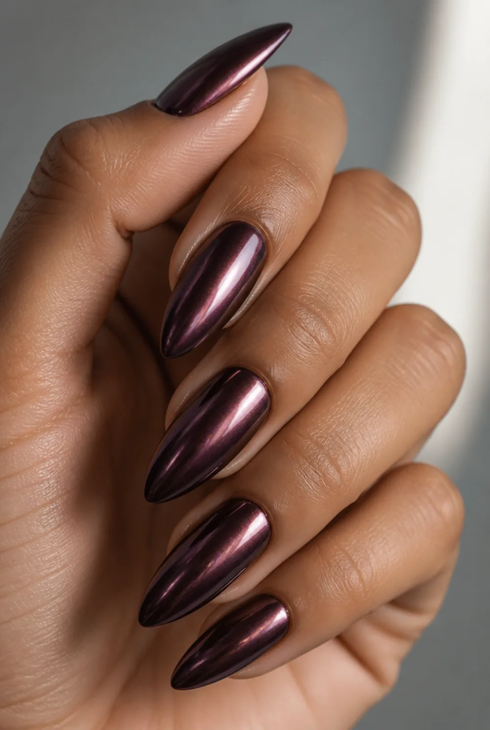 deep plum chrome nail art on olive skin, long length