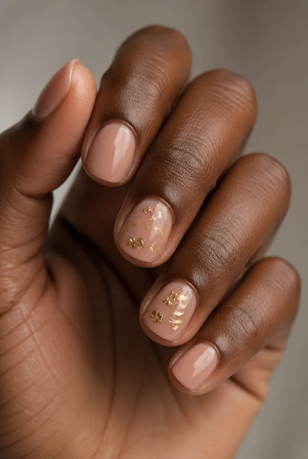 gold fleck accent nail art on deep brown skin