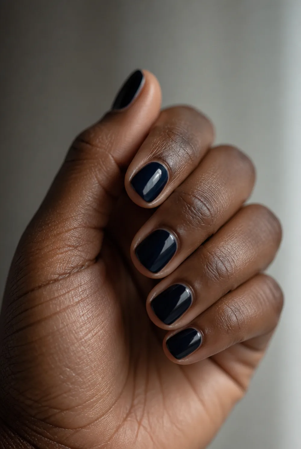 navy almost-black nail art on deep brown skin