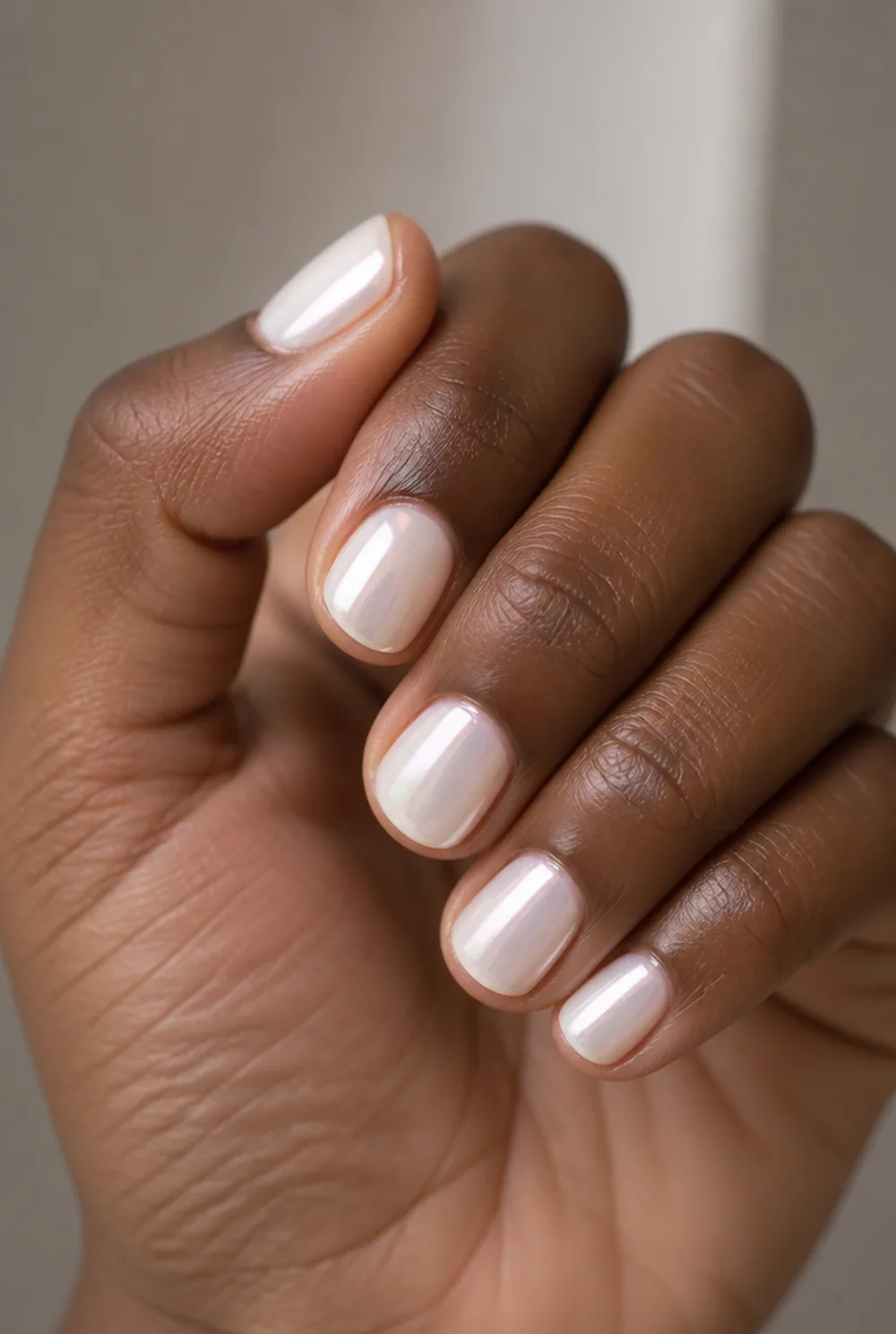 soft pearl chrome nail art on deep brown skin