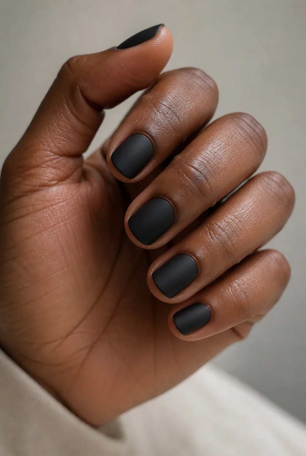 matte black tiny nail art on deep brown skin