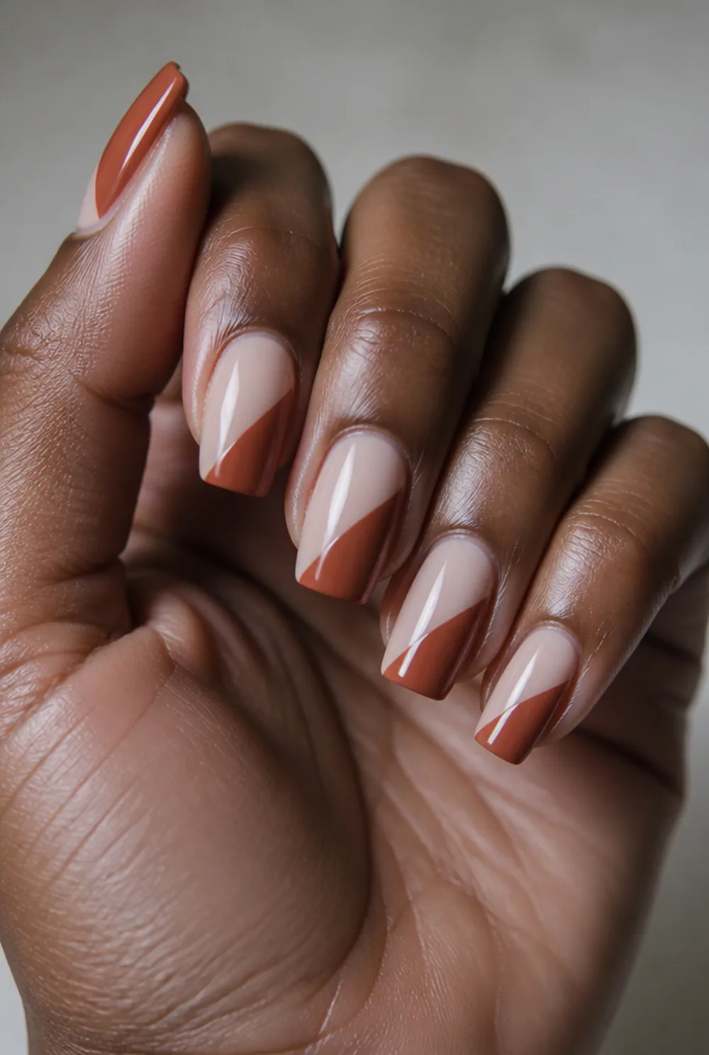 rust color-block nail art on deep brown skin