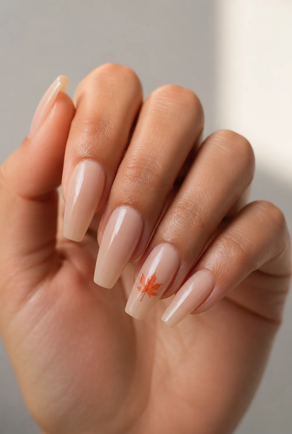 maple leaf on sheer nude nail art on olive skin, long length