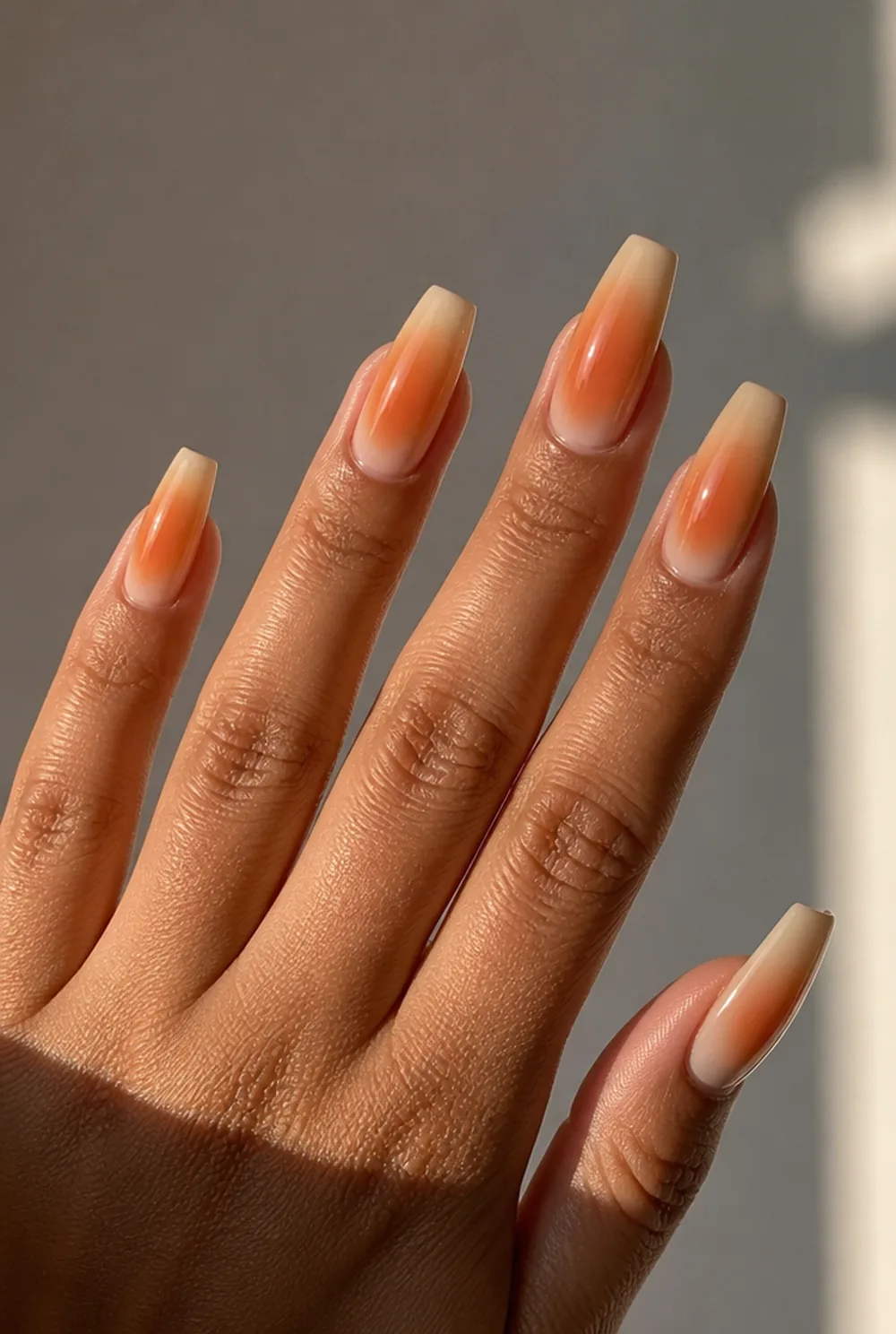 burnt orange aura nail art on olive skin, long length