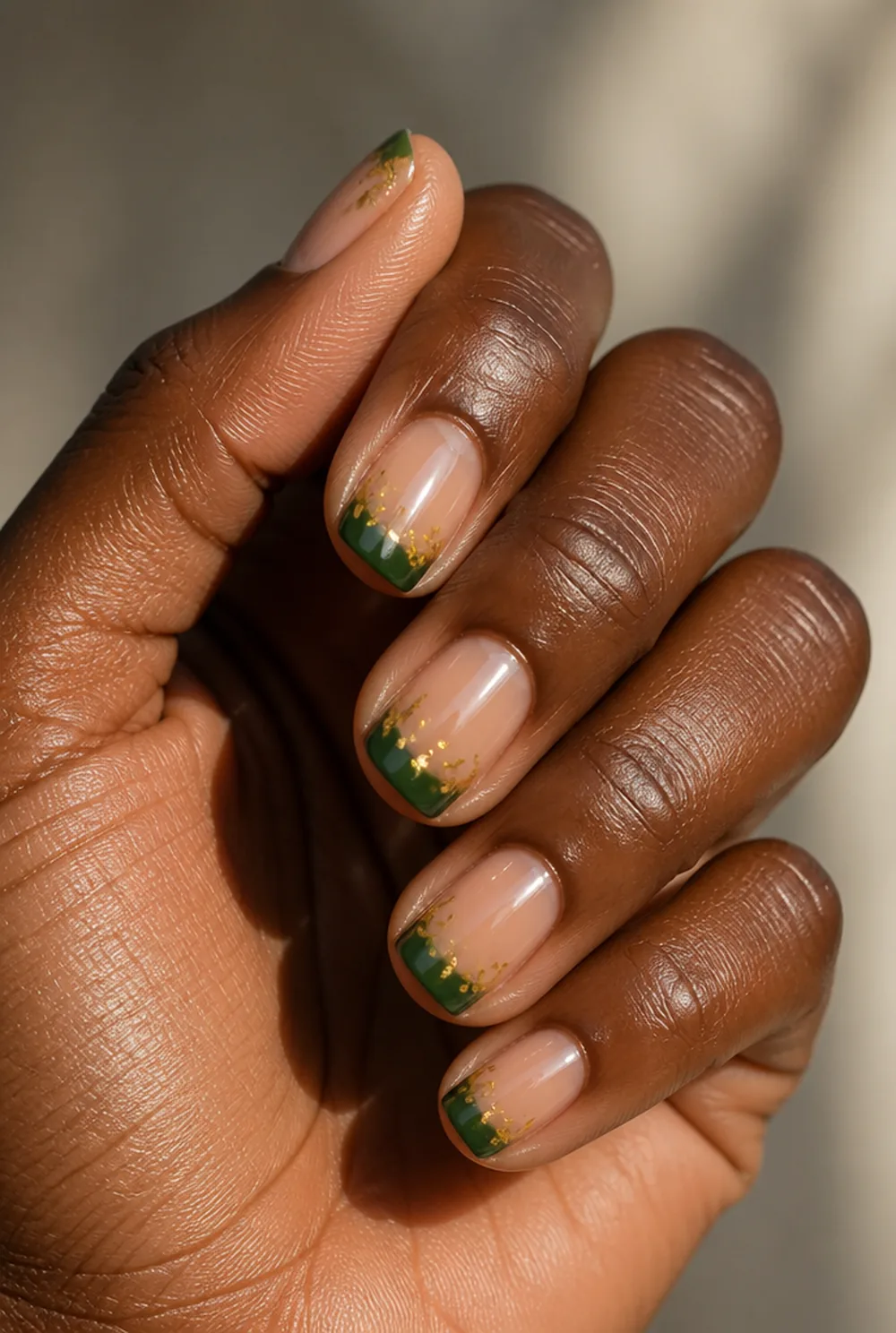 deep green tips with gold fleck nail art on deep brown skin