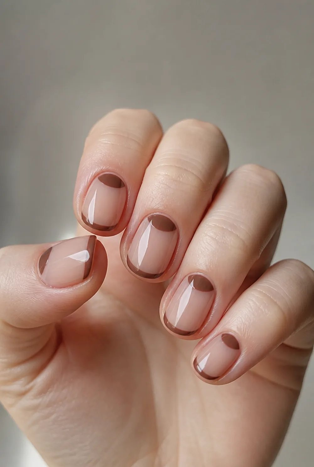 mocha half-moon and tip combo nail art on fair skin, short length
