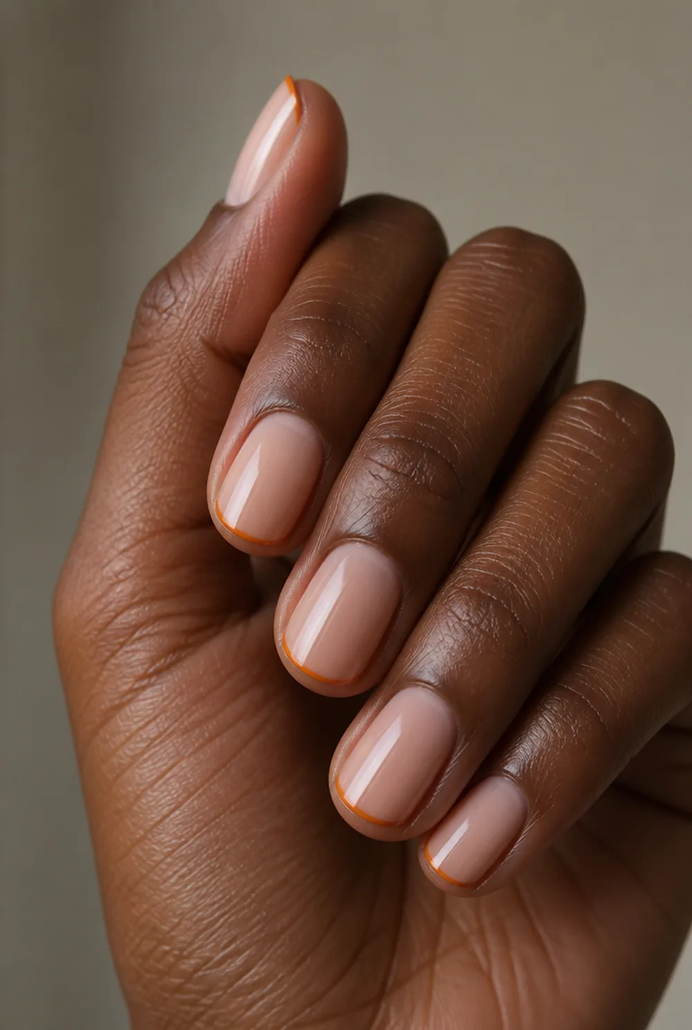 burnt orange micro-french nail art on deep brown skin