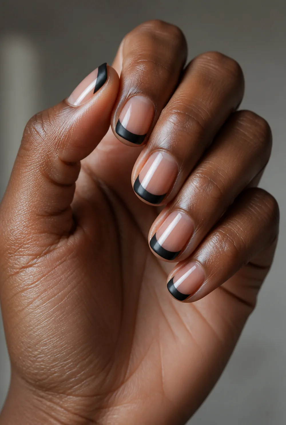 matte black french nail art on deep brown skin