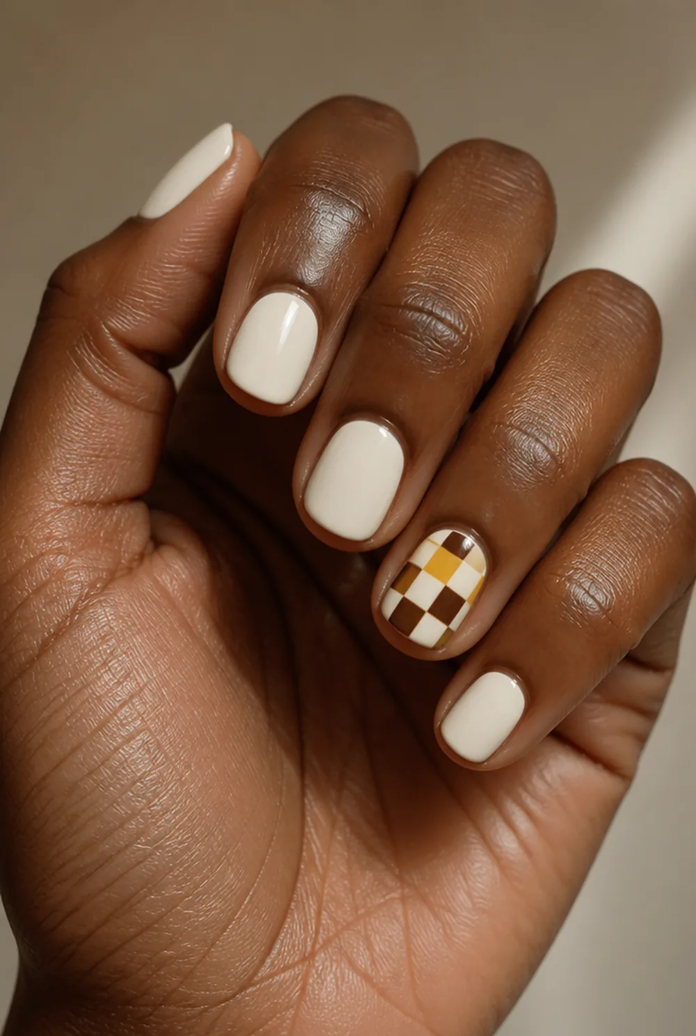 mustard and chocolate checkerboard nail art on deep brown skin