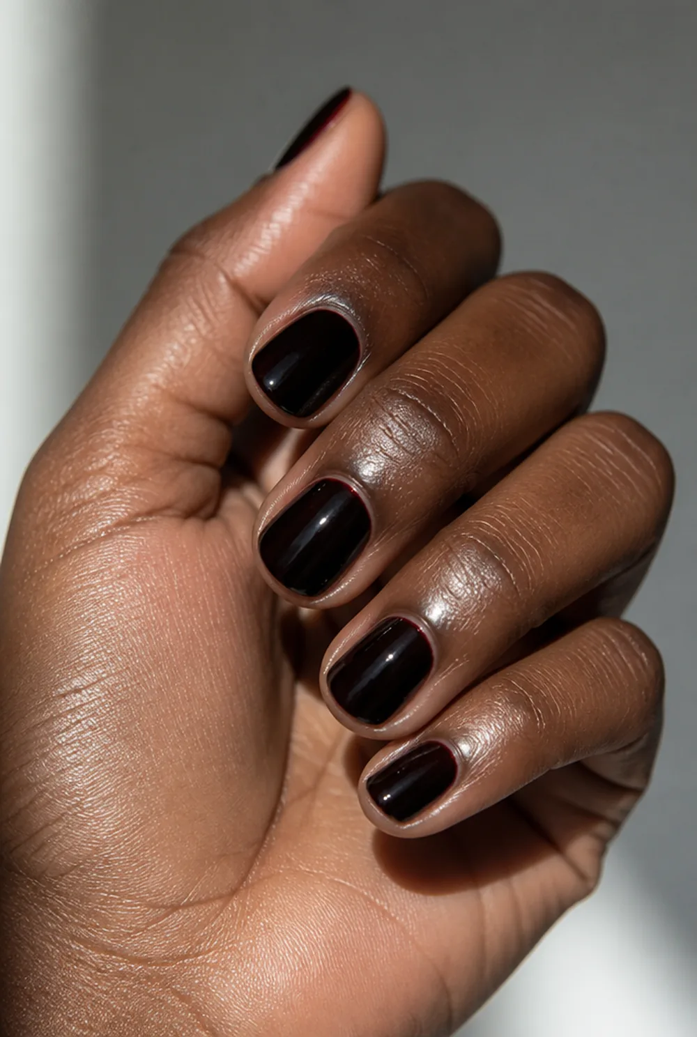 black cherry gloss nail art on deep brown skin