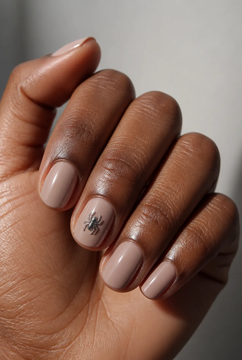 subtle spider charm nail art on deep brown skin - PolishedAndPrettyNails.com subtle spider charm nail art on deep brown skin