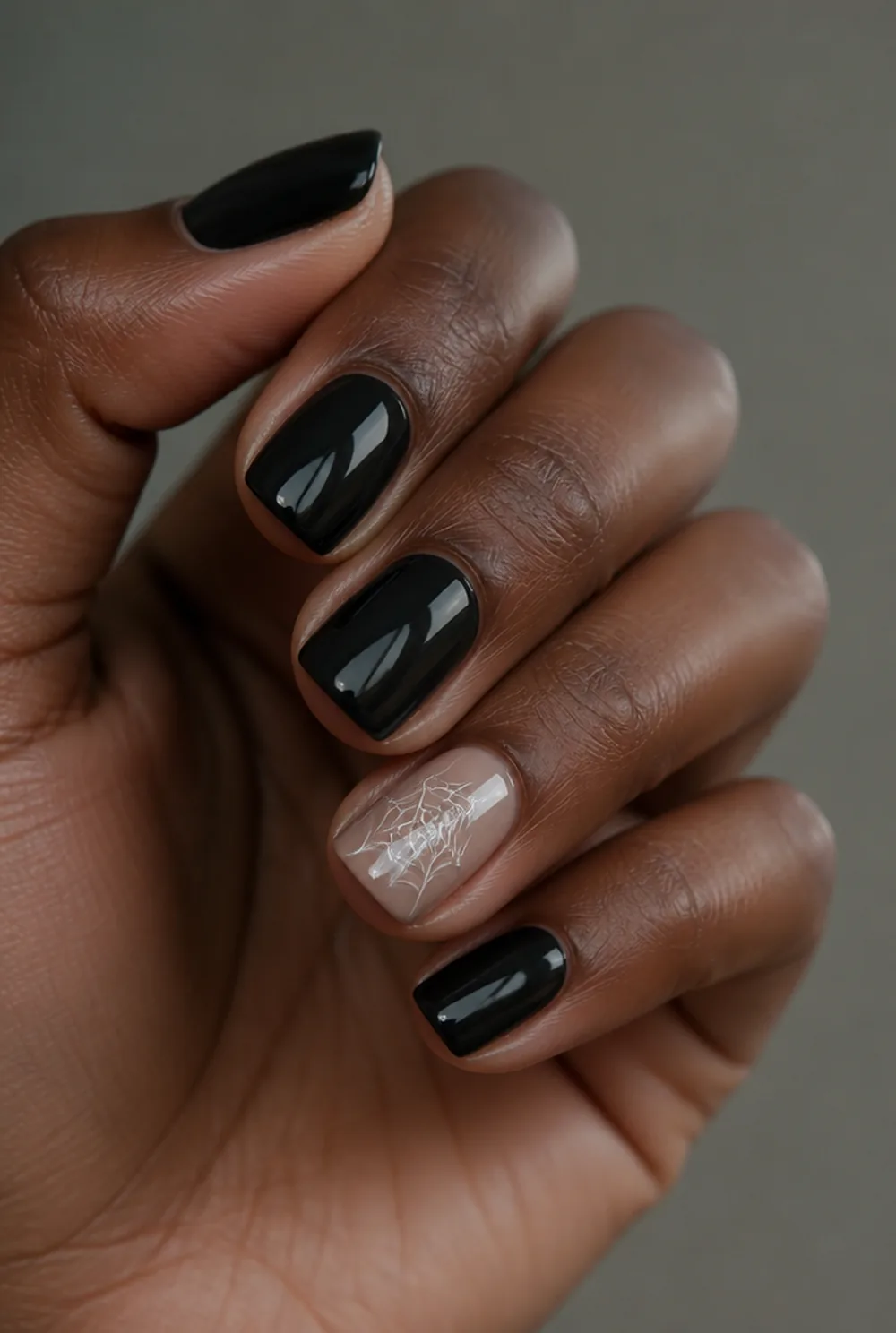 spiderweb accent nail art on deep brown skin