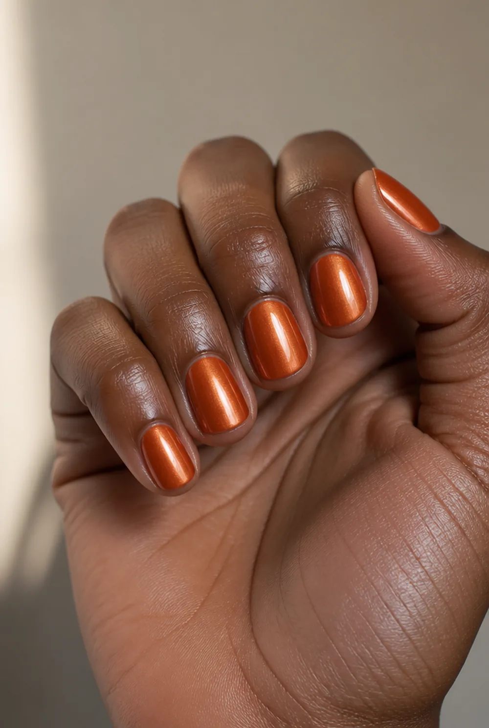 burnt orange chrome nail art on deep brown skin