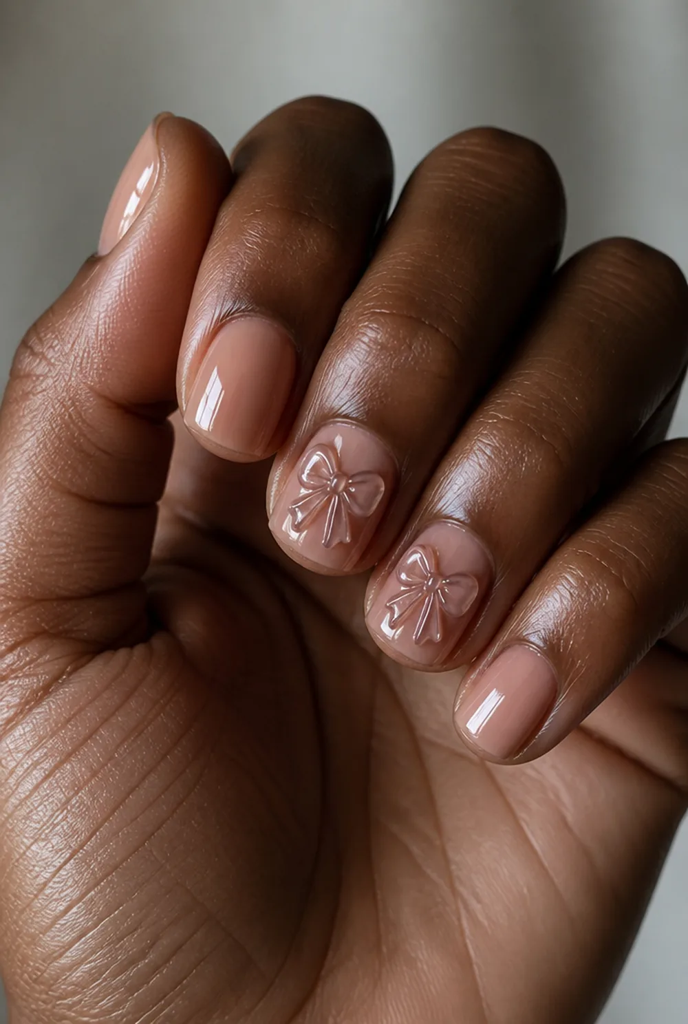 3d bows nail art on deep brown skin