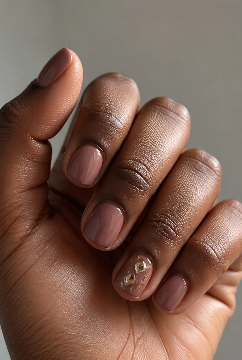 charm placement nail art on deep brown skin