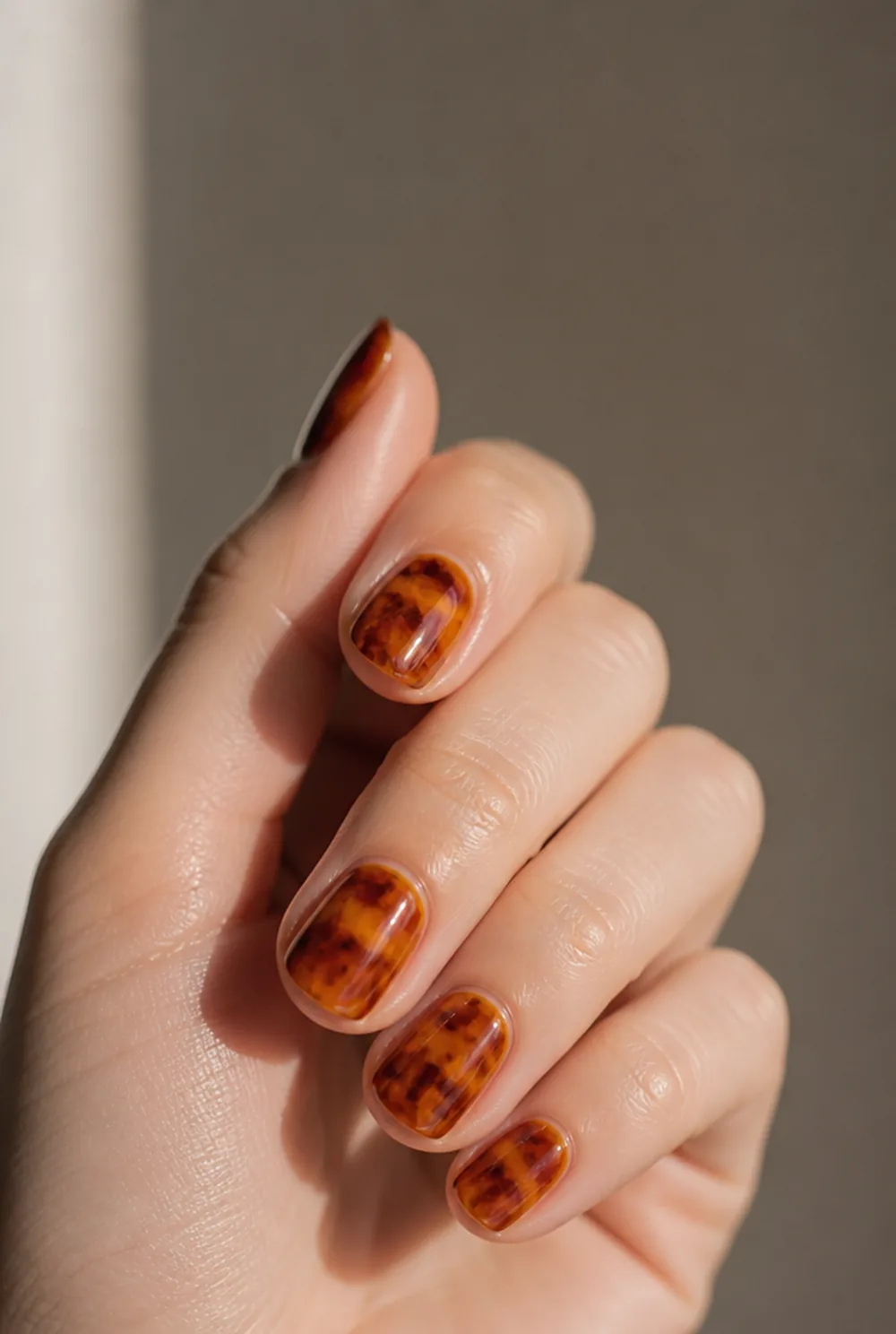 tortoise shell nail art on fair skin, short length