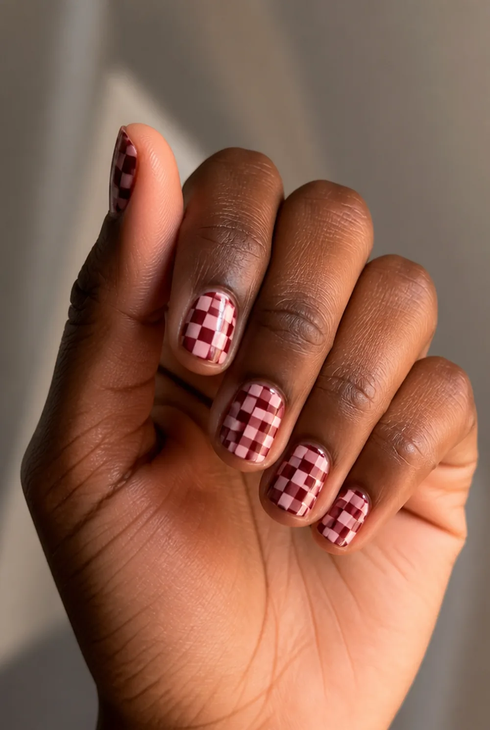 checkerboard nail art on deep brown skin