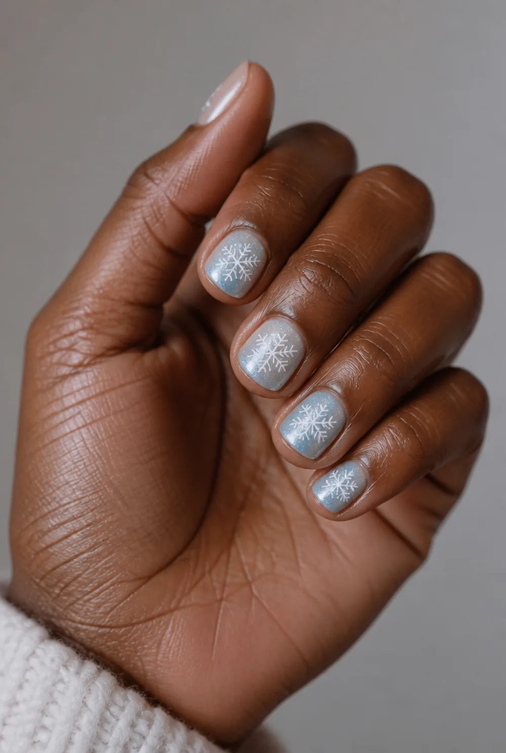 snowflake accent nail art on deep brown skin