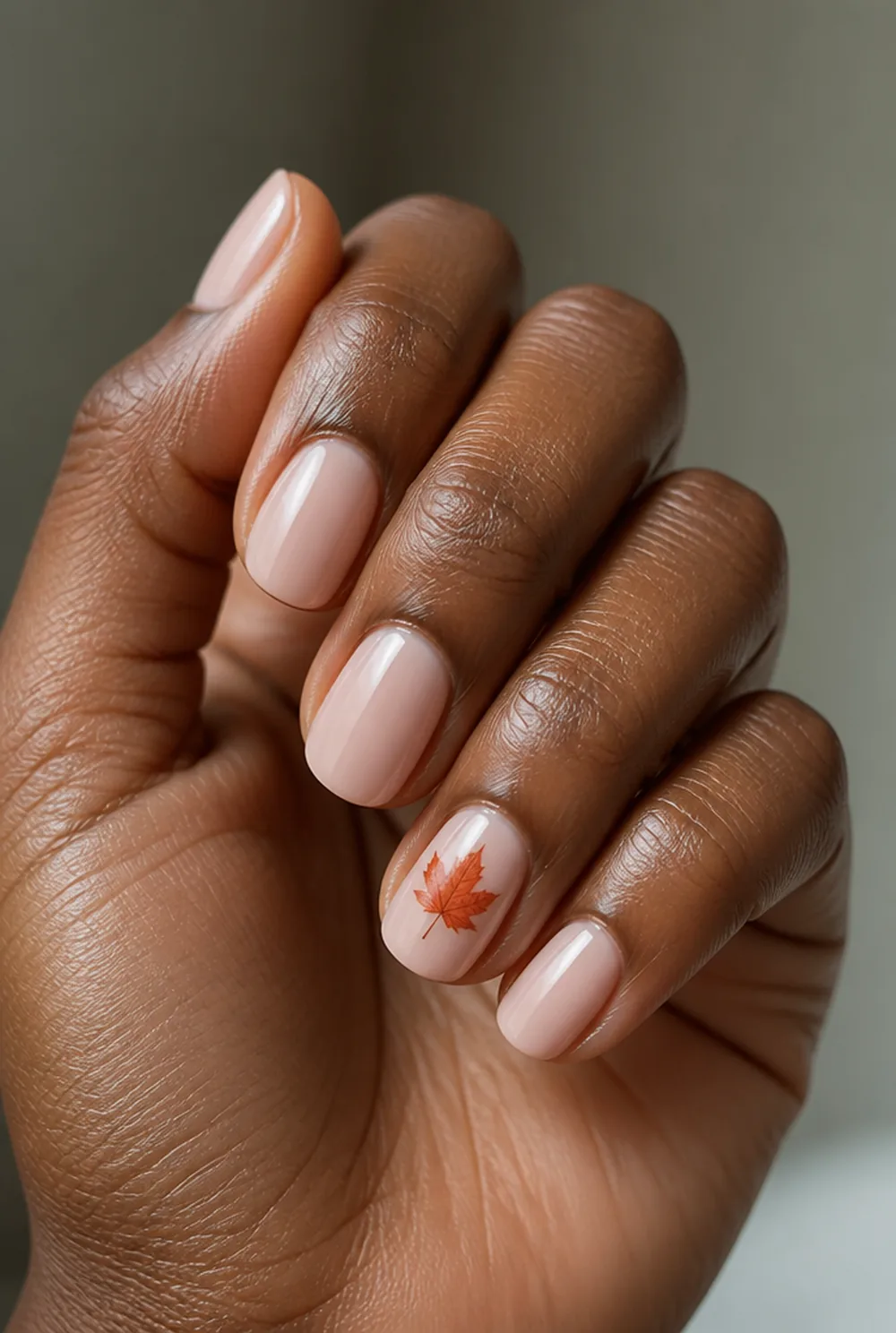 maple leaf accent nail art on deep brown skin