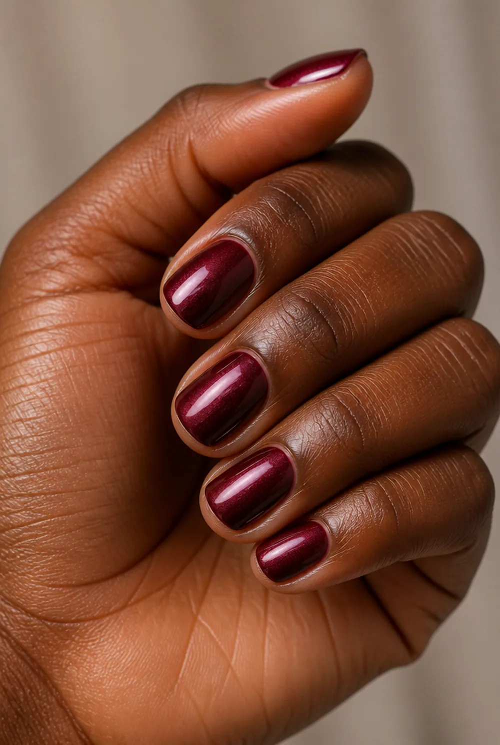 burgundy glazed chrome nail art on deep brown skin