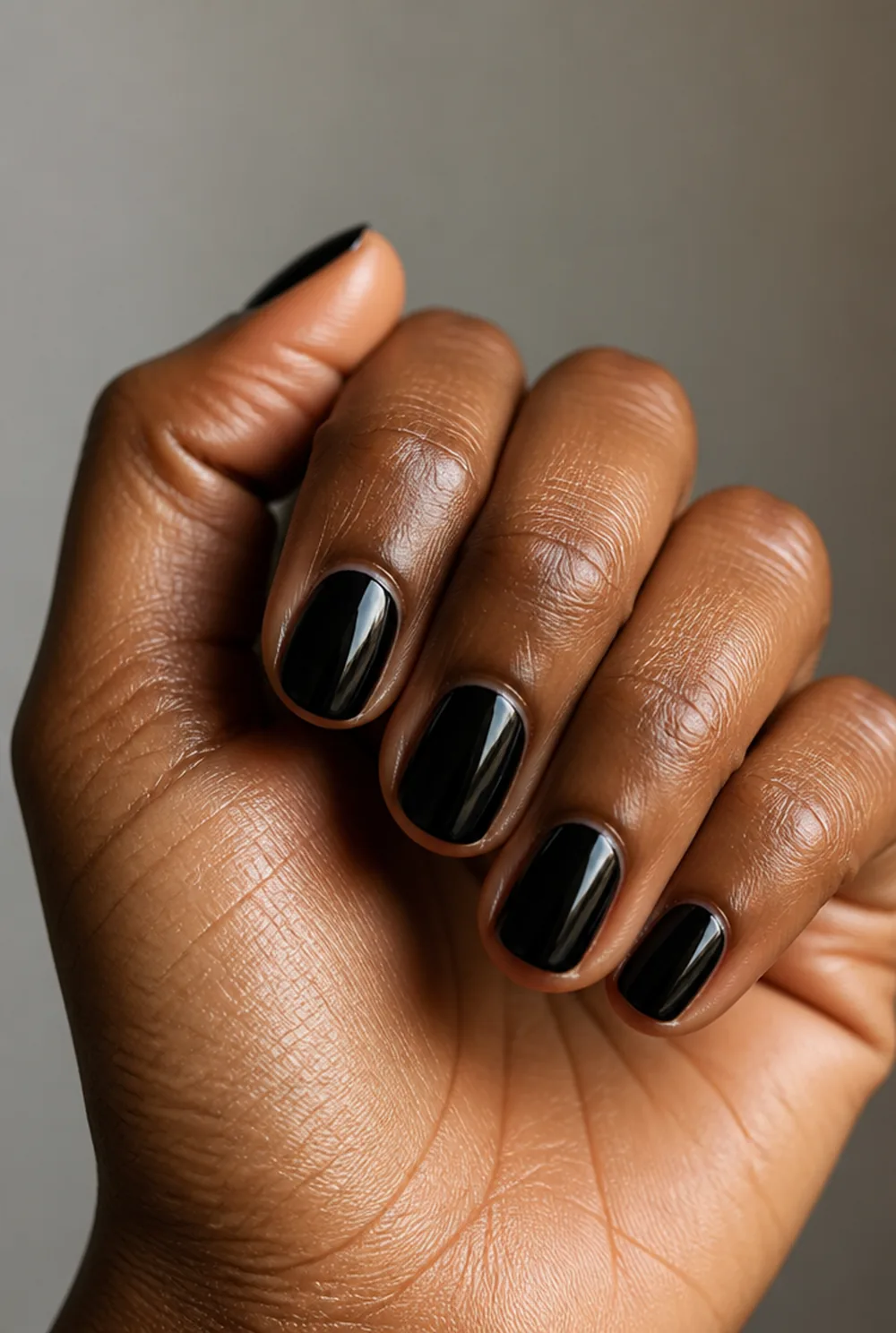 black gloss nail art on deep brown skin