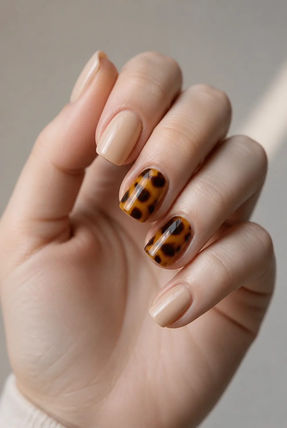 tortoiseshell accent nail art on fair skin, short length