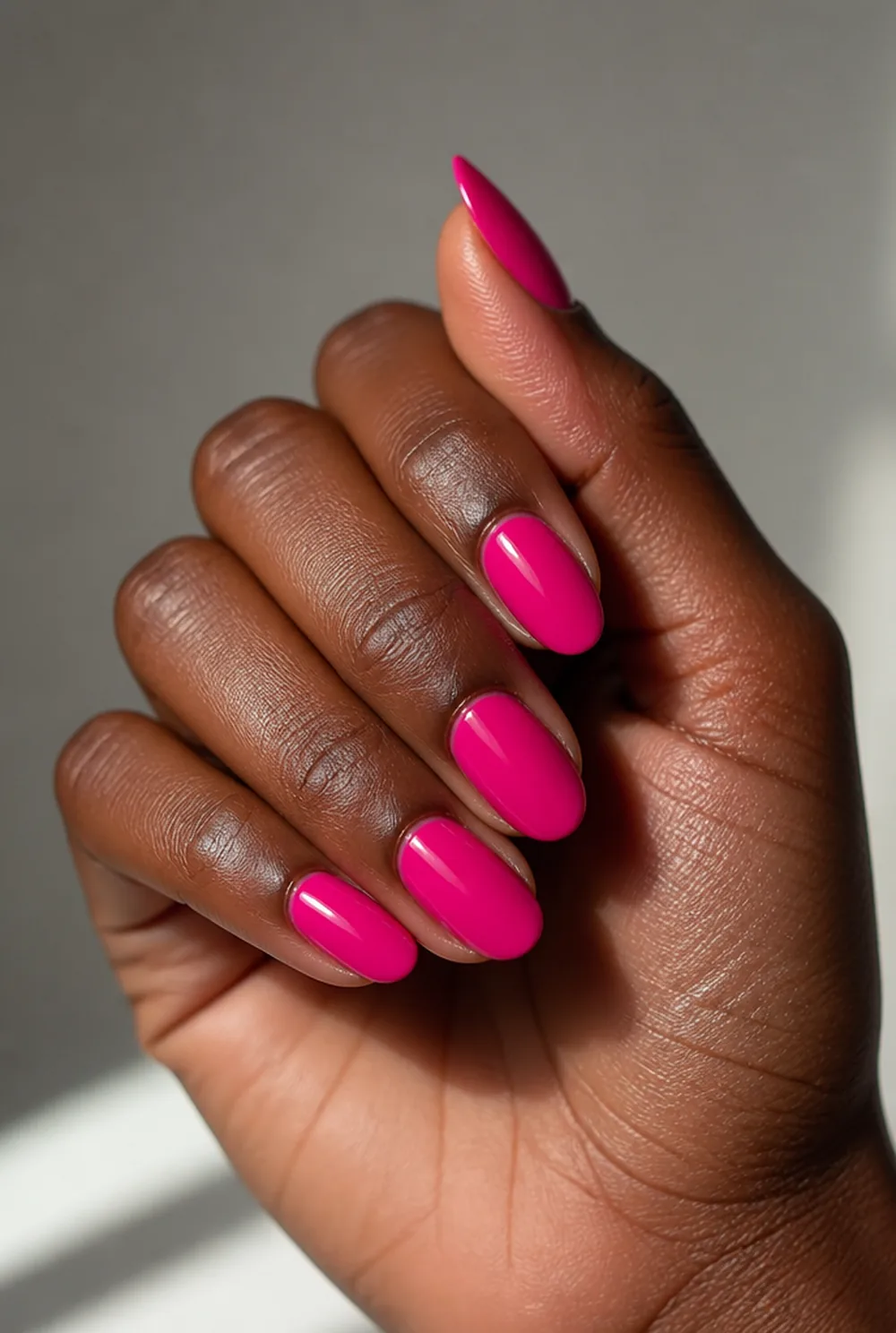 hot pink almond nail art on deep brown skin