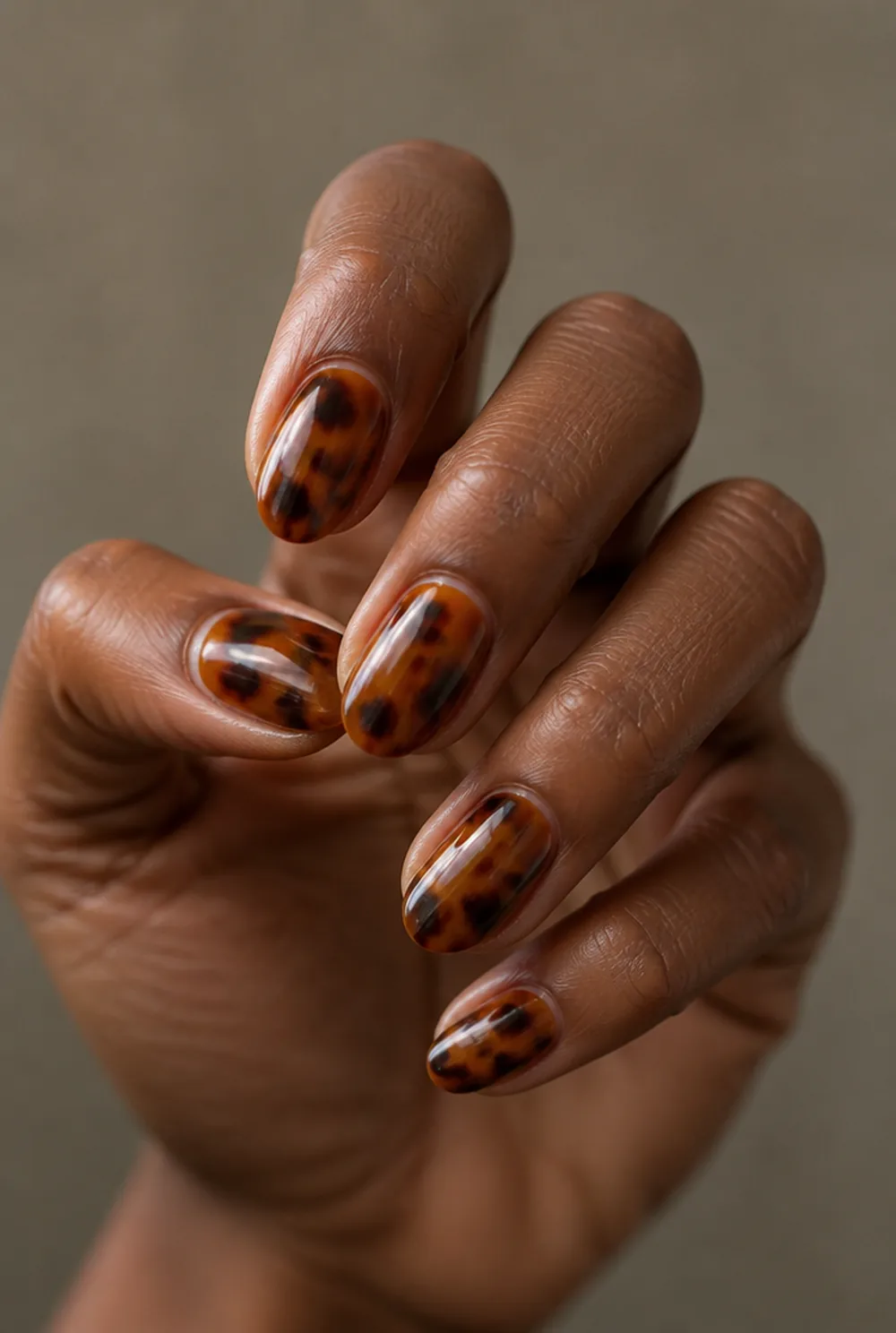 almond tortoiseshell nail art on deep brown skin