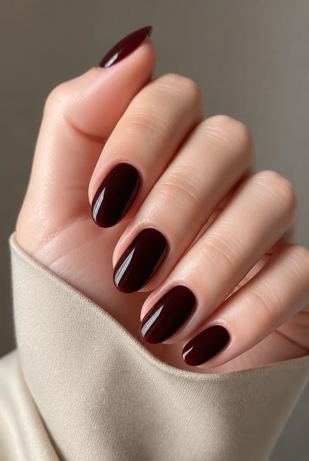 blackened cherry almond nail art on fair skin, short length