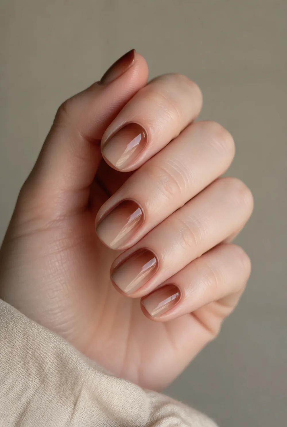 brown aura nail art on fair skin, short length