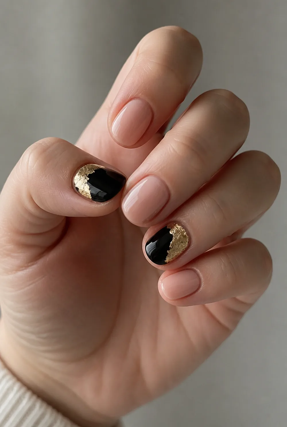 black and gold nail art on fair skin, short length