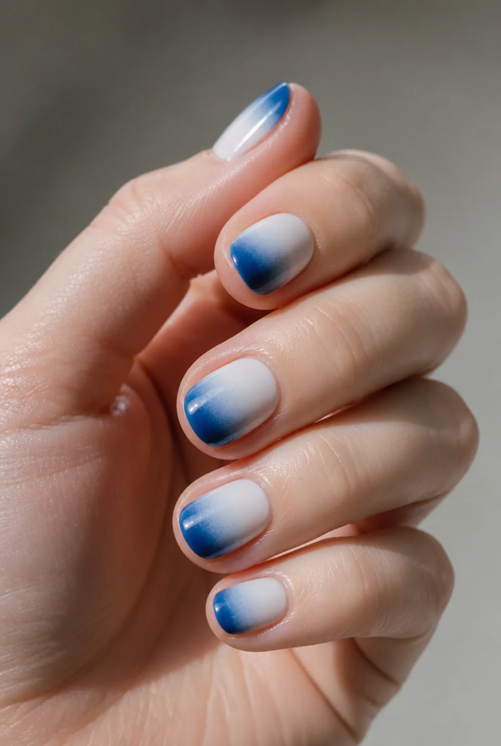 blue ombre fade nail art on fair skin, short length