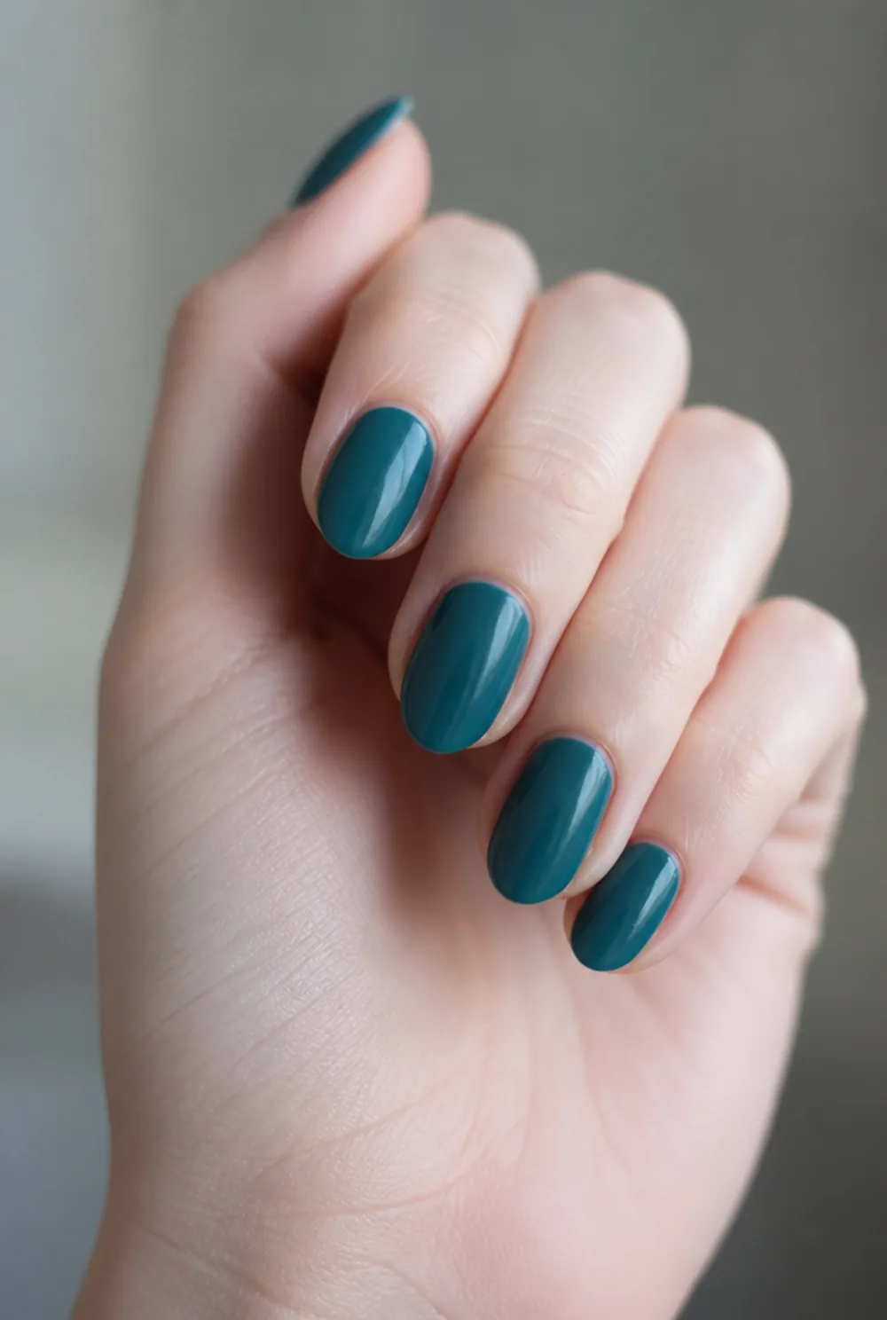 teal deep nail art on fair skin, short length