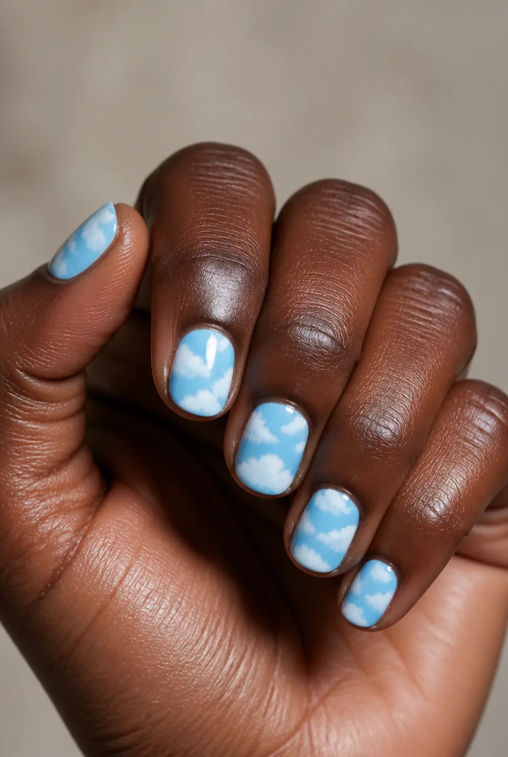 blue sky clouds nail art on deep brown skin