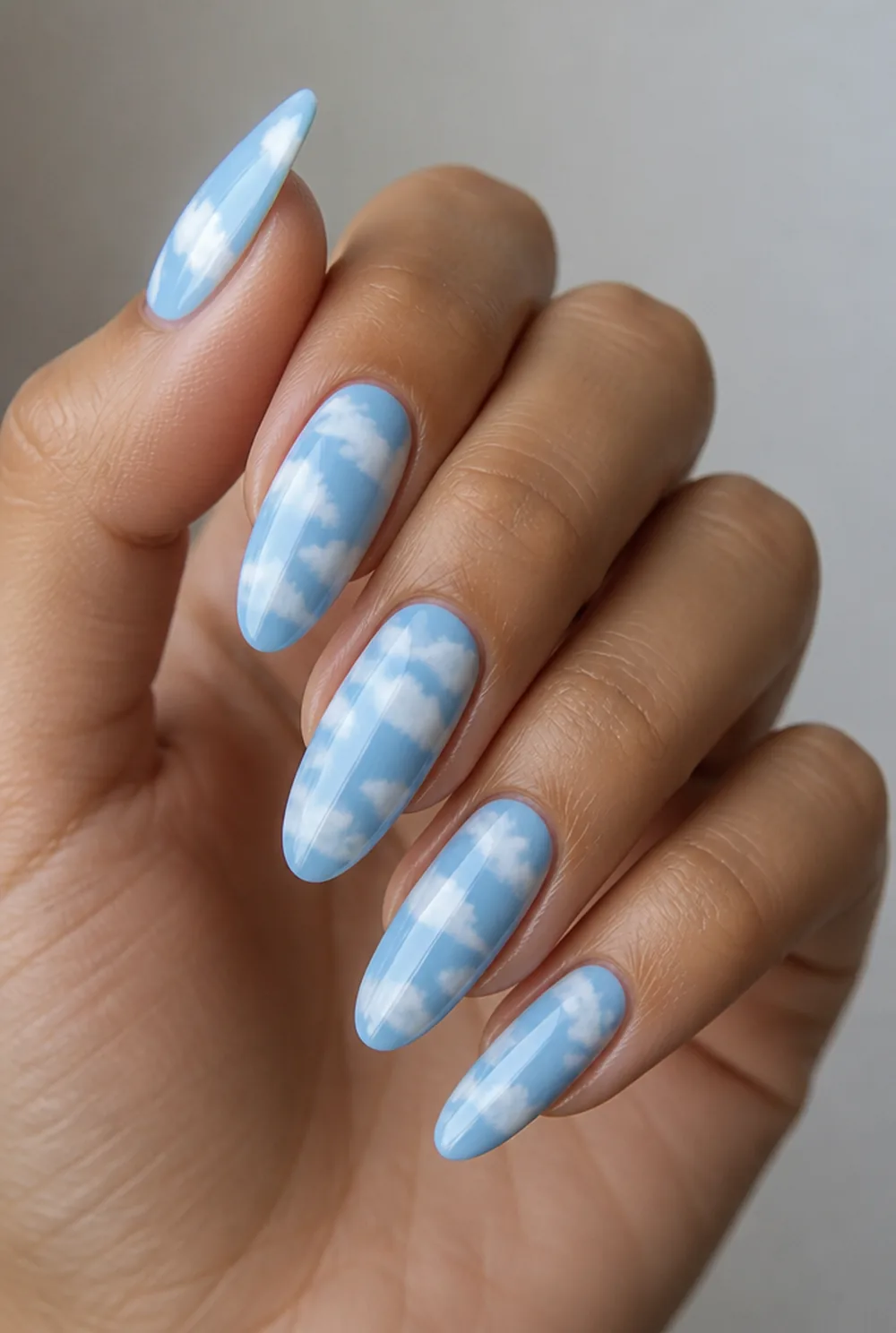blue sky clouds nail art on olive skin, long length