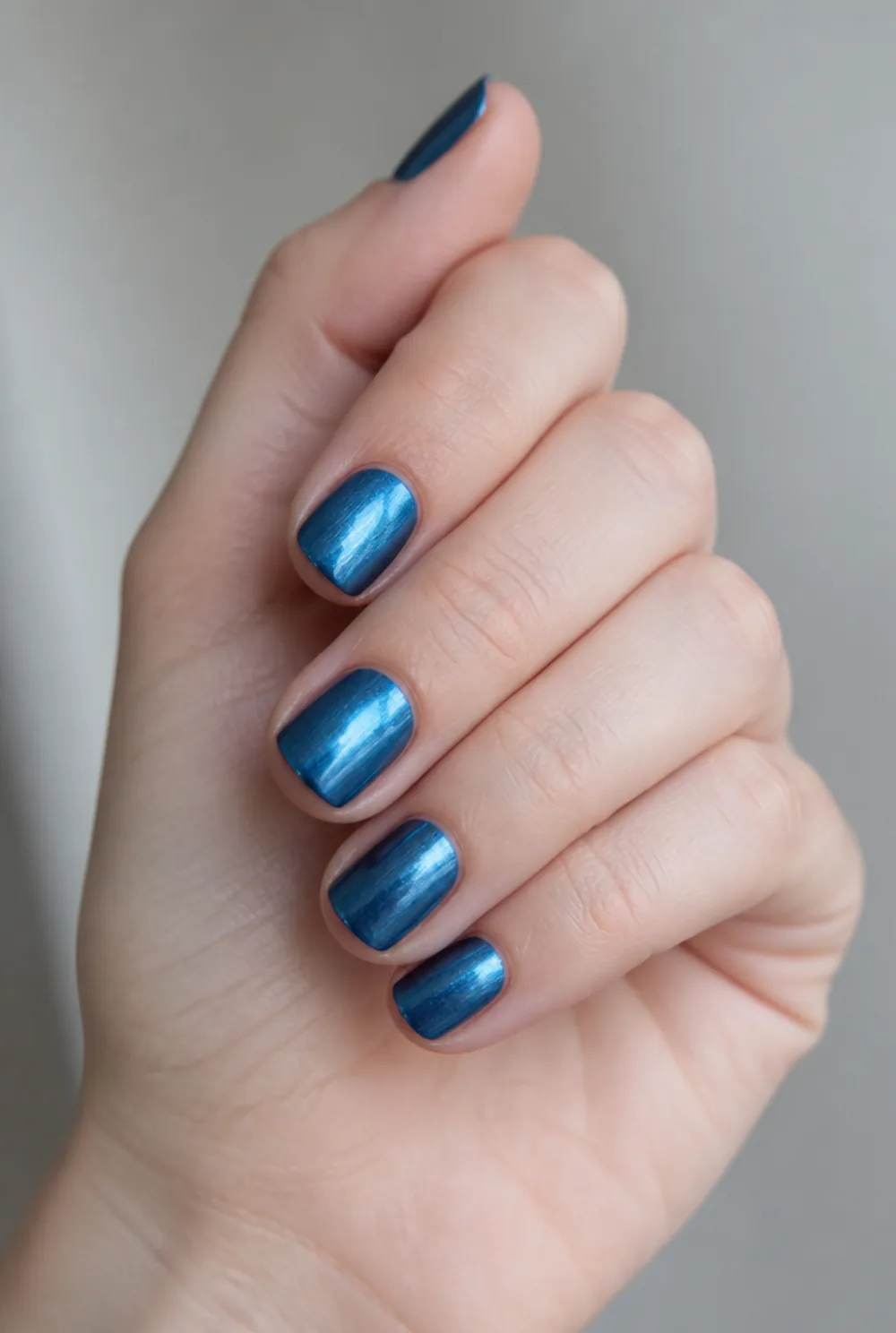blue chrome mirror nail art on fair skin, short length