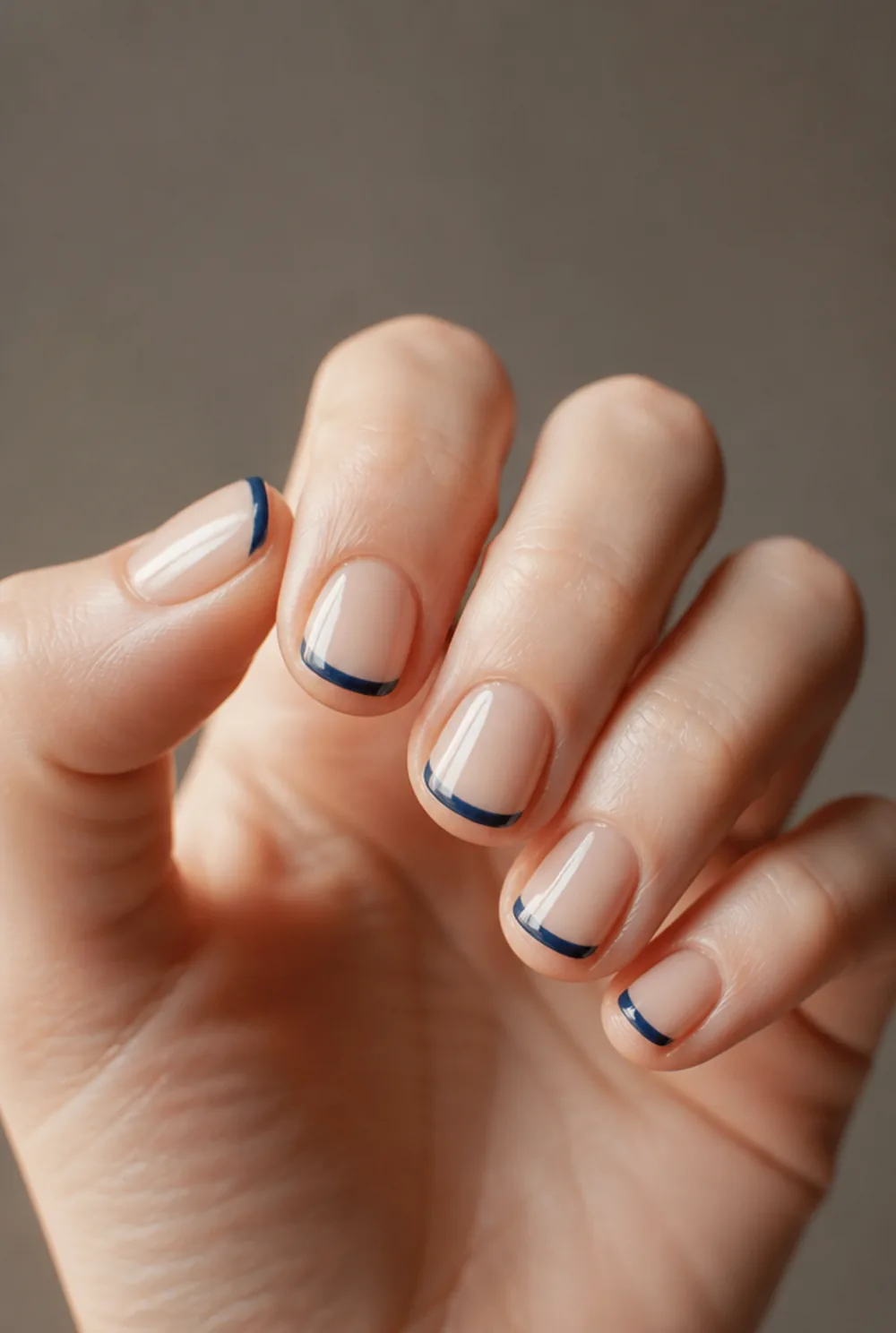 navy french tip nail art on fair skin, short length